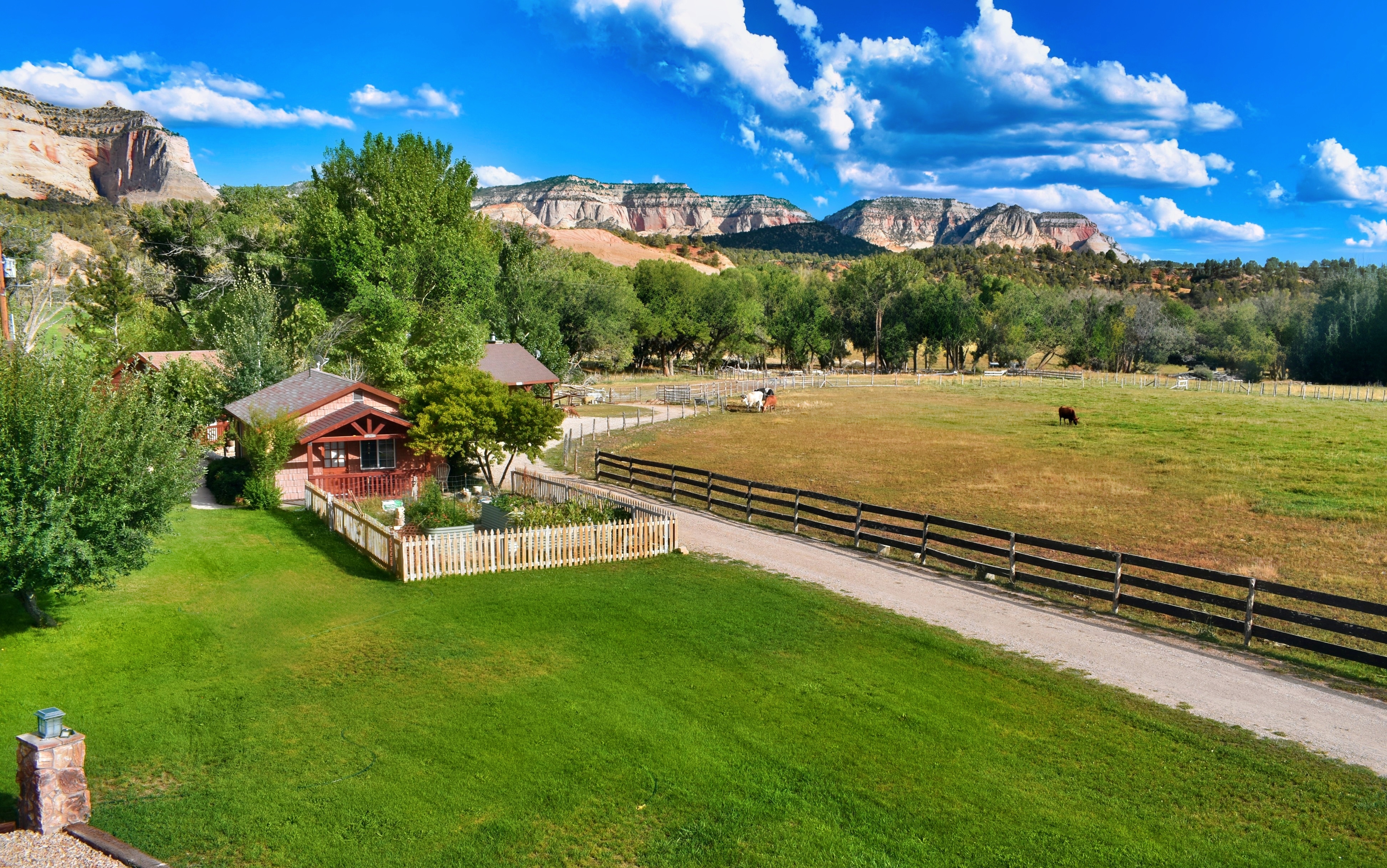 A wide exterior view of a cabin-style hotel with a mountain view.